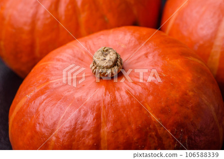 Beautiful fresh round pumpkins in orange color on a dark concrete background 106588339