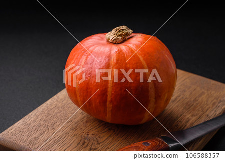 Beautiful fresh round pumpkins in orange color on a dark concrete background Beautiful fresh round pumpkins in orange color on a dark concrete background 106588357