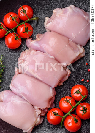 Fresh raw chicken thigh fillets with salt, spices and herbs 106588372