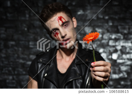 Waist up photo of a zombie boy with no emotions on his face, standing in front of a brick wall with blood on his face stretching a flower, selective focus Waist up photo of a zombie boy with no emotions on his face, standing in front of a brick wall with blood on his face stretching a flower, selective focus 106588615
