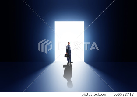 Businessman entering backlit door in escape concept Businessman entering backlit door in escape concept 106588718
