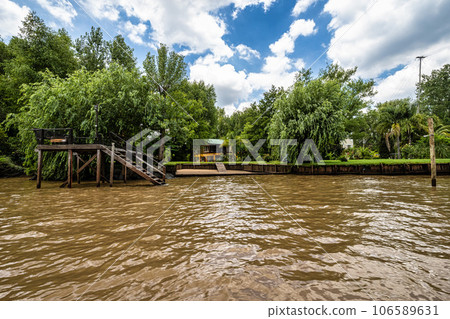 Boat tour on the Parana Delta, Tigre, Buenos Aires, Argentina. Palm trees, construction site of modern brick house. 106589631