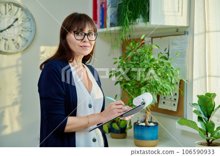 Portrait of specialist woman with clipboard in office 106590933