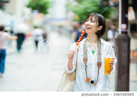 一個女人邊走邊吃 一個女人在旅行 一個女人在唐人街觀光 106590989