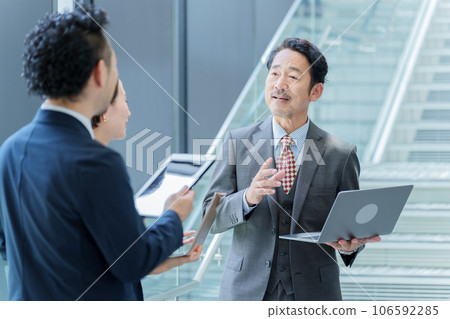 Business people standing and talking in front of the stairs 106592285