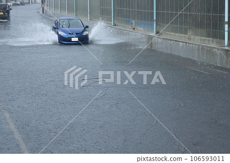一輛汽車在被大雨淹沒的道路上行駛 106593011