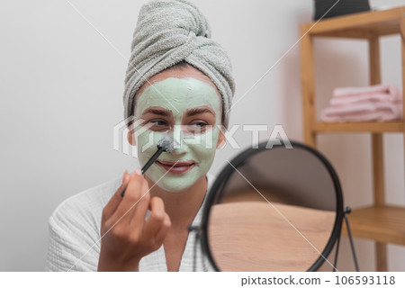 Skin's Rejuvenation: She pampers her face with a moisturizing mask, revealing revitalized, glowing skin at home.  106593118