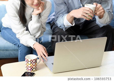 Asian men and women looking at laptops indoors Asian men and women looking at laptops indoors 106593753