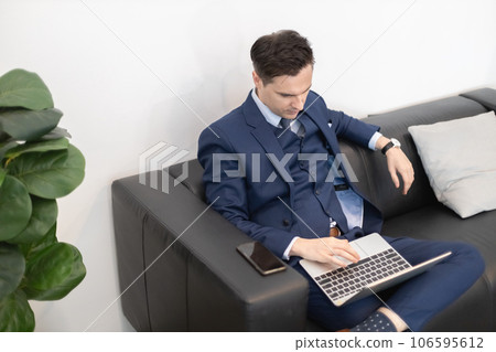 Attractive businessman using laptop at table office. Attractive businessman using laptop at table office. 106595612
