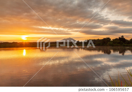 Mt. Tsukuba and the rays of the sunrise reflected on the water surface of the water pond on Mokojima, Ibaraki Prefecture Mt. Tsukuba and the rays of the sunrise reflected on the water surface of the water pond on Mokojima, Ibaraki Prefecture 106595657