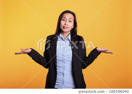 Doubtful filipino woman doing i dont know gesture, having problem understanding question. Confused model shrugging shoulders standing in studio over yellow background. Clueless expression Doubtful filipino woman doing i dont know gesture, having problem understanding question. Confused model shrugging shoulders standing in studio over yellow background. Clueless expression 106596040