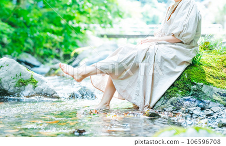 一個女人把腳浸入河裡 106596708