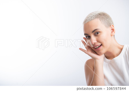 Pretty young woman with a short blond haircut on a white background. 106597844