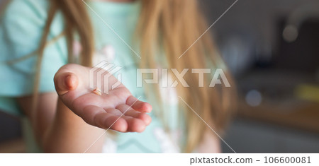Little girl's hand holding and showing her fallen milk front tooth close up. Little girl's hand holding and showing her fallen milk front tooth close up. 106600081