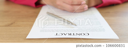 Woman sitting at table in office, signing contract agreement Woman sitting at table in office, signing contract agreement 106600831