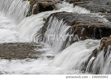Water flowing down the weir 106600902
