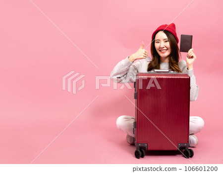 Young Asian Woman Traveler with a Smile Gives Thumbs up. Enjoying a Happy Vacation Journey, Holding Her Passport in Pink Background Isolated. Representing the Joy of Travel and Adventure Young Asian Woman Traveler with a Smile Gives Thumbs up. Enjoying a Happy Vacation Journey, Holding Her Passport in Pink Background Isolated. Representing the Joy of Travel and Adventure 106601200