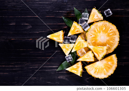 Fresh pineapple on black wood, black background. 106601305