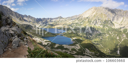 Beautiful alpine valley with mountain peaks, lakes, and some vegetation, panoramic, Poland, Europe 106603668
