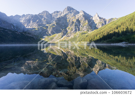 Majestic rocky mountain reflecting in pristine crystal clear alpine lake, Poland, Europe 106603672