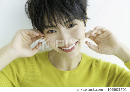 白色背景下身穿黃色衣服的微笑年輕女子的肖像 106603701