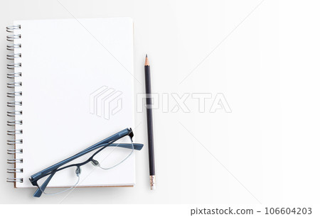 Blank paper notebook and glasses on white table background 106604203