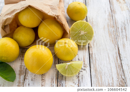 Freshly lemons in paper bag on white wooden table 106604542