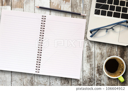 Top view blank notebook,glasses and coffee mug on office desk with laptop computer. 106604912