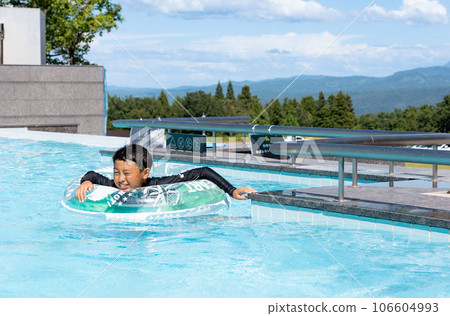 Asian boy playing in outdoor pool 106604993