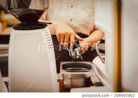 Barista preparation tampering coffee in portafilter for making fresh coffee. 106605002