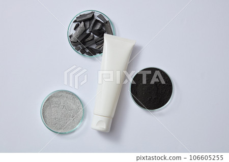 Clay mask powder, black powder and activated bamboo charcoal are displayed inside petri dishes. Blank label tube for branding mockup design of activated bamboo charcoal extract Clay mask powder, black powder and activated bamboo charcoal are displayed inside petri dishes. Blank label tube for branding mockup design of activated bamboo charcoal extract 106605255