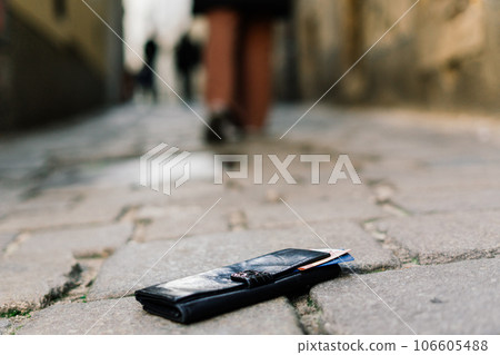 Photo of the sidewalk and legs of a man who lost a black leather wallet while walking Photo of the sidewalk and legs of a man who lost a black leather wallet while walking 106605488