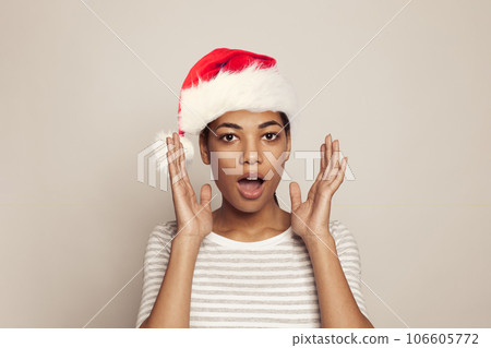 Young attractive surprised Christmas woman in red Santa hat, Xmas portrait 106605772