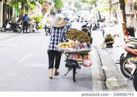 Rear view of a woman selling fruit from a bicycle in Hanoi's Old Quarter 106606743