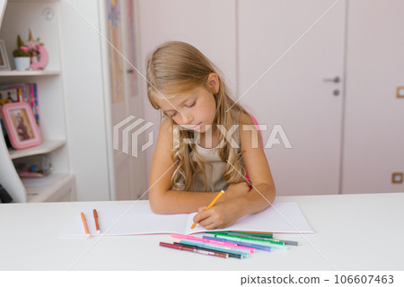 Seven year old schoolgirl is doing homework at her desk at home or at school, drawing with felt-tip pens Seven year old schoolgirl is doing homework at her desk at home or at school, drawing with felt-tip pens 106607463