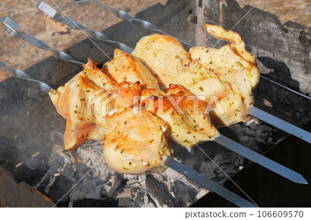Meat frying on grill. Fried pieces of pork and beef skewers on coals in open air. Roasted meat background. Meat frying on grill. Fried pieces of pork and beef skewers on coals in open air. Roasted meat background. 106609570