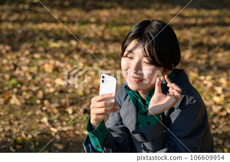 A woman taking a photo of the acorns she picked up 106609954