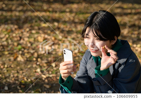 A woman taking a photo of the acorns she picked up 106609955
