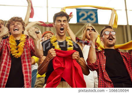 Win. Group of emotional young people, sports fans, enthusiasts cheering up favourite team during game, match 106610094