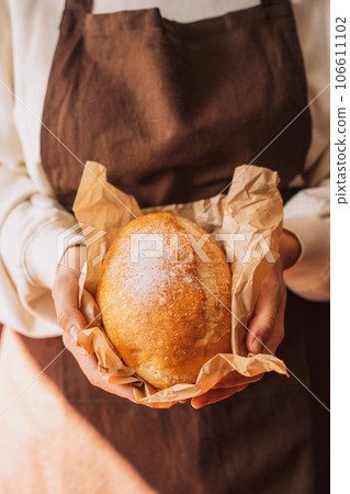 Fresh loaf of bread with ears of wheat and pumpkin on a wooden table 106611102