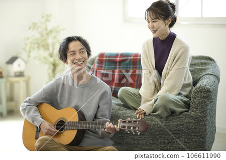 年輕夫婦在房間裡彈吉他唱歌 106611990