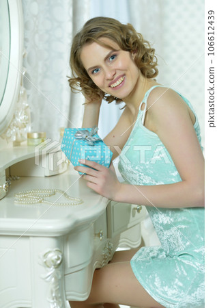 young cute woman with gift at home young cute woman with gift at home 106612439