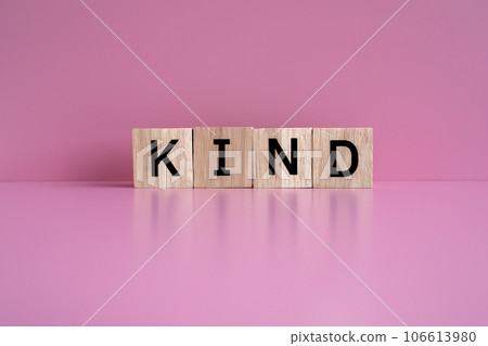 Wooden blocks form the text "KIND" against a pink background. 106613980