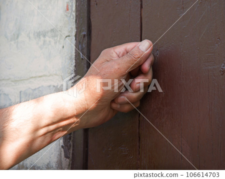 Man's hand knocking on the door 106614703