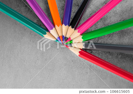 Colorful pencils and grey paper. Empty place for text or drawing. Childhood creative art concept. Flat lay. Colorful pencils and grey paper. Empty place for text or drawing. Childhood creative art concept. Flat lay. 106615605