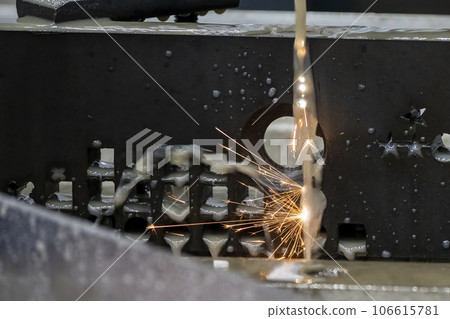 Closeup scene the wire EDM machine cutting the mold insert parts with the sparkling light. Closeup scene the wire EDM machine cutting the mold insert parts with the sparkling light. 106615781