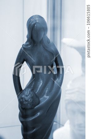 Art object printed on 3D printer. Figure of a woman of blue color. Model printed on 3D printer from melted plastic. Object printed close-up. Concept new modern innovation printing technology Art object printed on 3D printer. Figure of a woman of blue color. Model printed on 3D printer from melted plastic. Object printed close-up. Concept new modern innovation printing technology 106615805