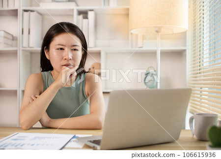 Woman using laptop to work or do homework at home with smiling face in her office, Creating happiness at work with a smile, Live performance or vdo call with laptop, Work from home. 106615936
