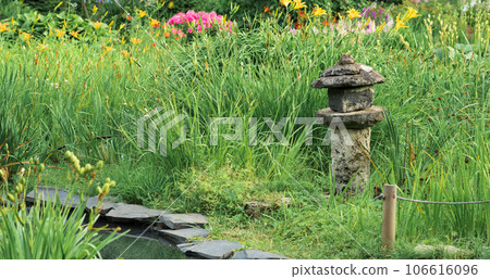 stone lantern among grass on the bank of a pond in a Japanese garden stone lantern among grass on the bank of a pond in a Japanese garden 106616096