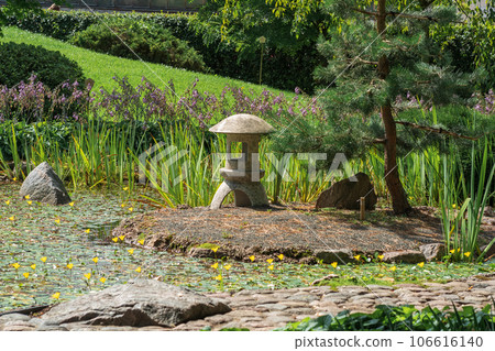 stone lantern on a small island in the middle of a pond in a Japanese garden stone lantern on a small island in the middle of a pond in a Japanese garden 106616140